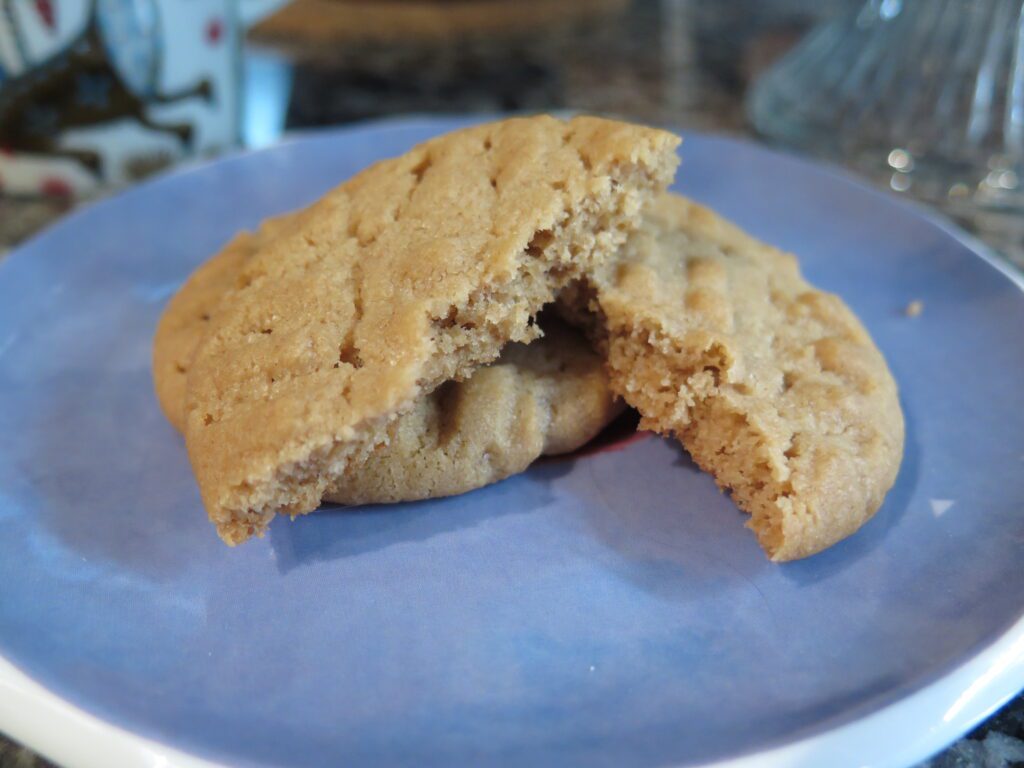 Peanut Butter Cookies - plate with a couple of cookies - one showing the inside of the cookie