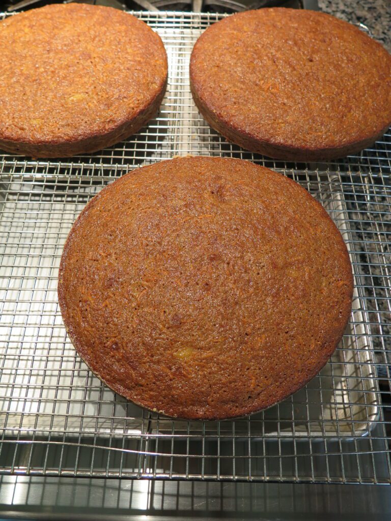 3 carrot cakes cooling on a rack